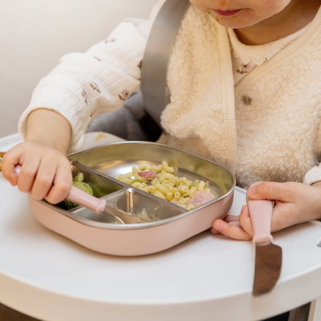 Child using cutlery with a Cotton Candy Beaba stainless steel divided plate
