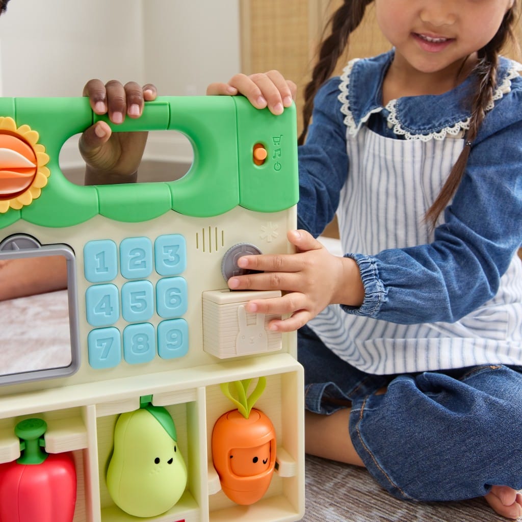 Child exploring the coin box on the Farmstand activity panel