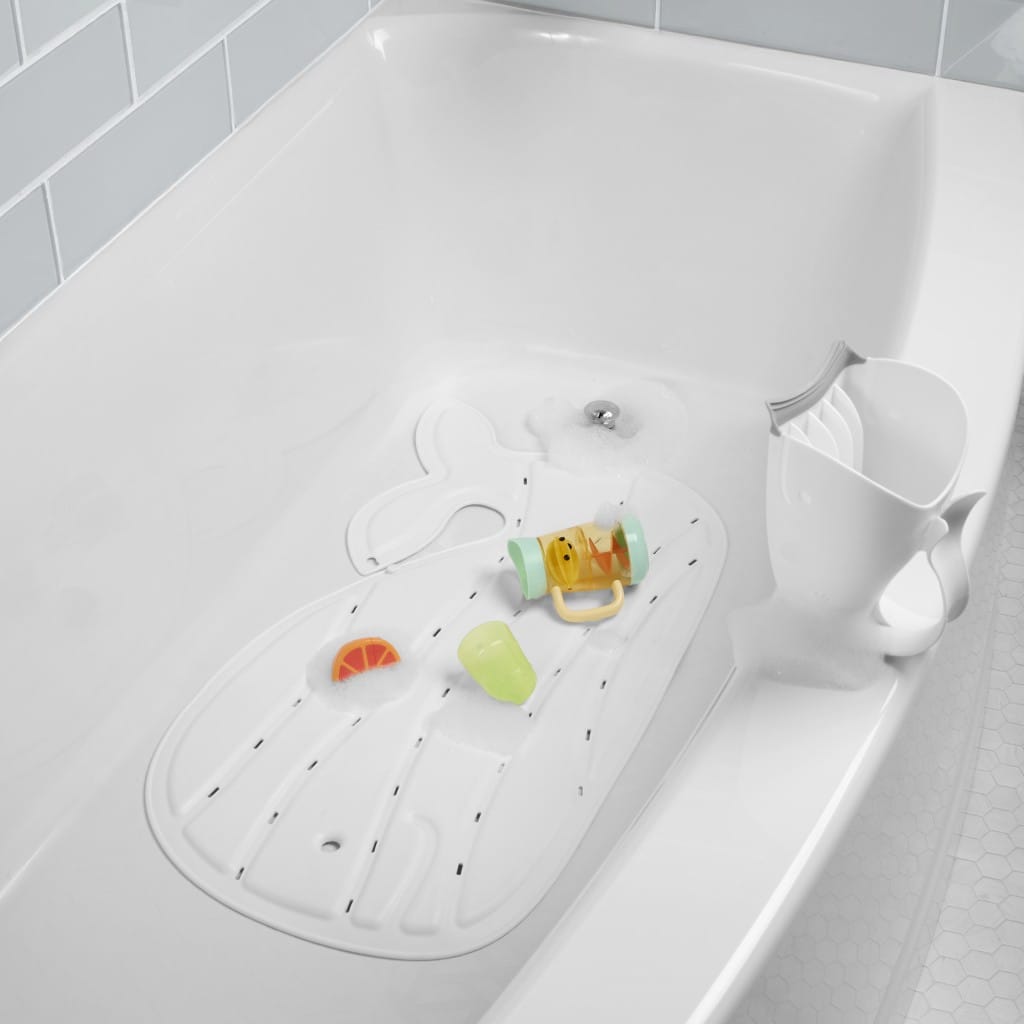 White Moby bath mat positioned in a bath with colourful bath toys