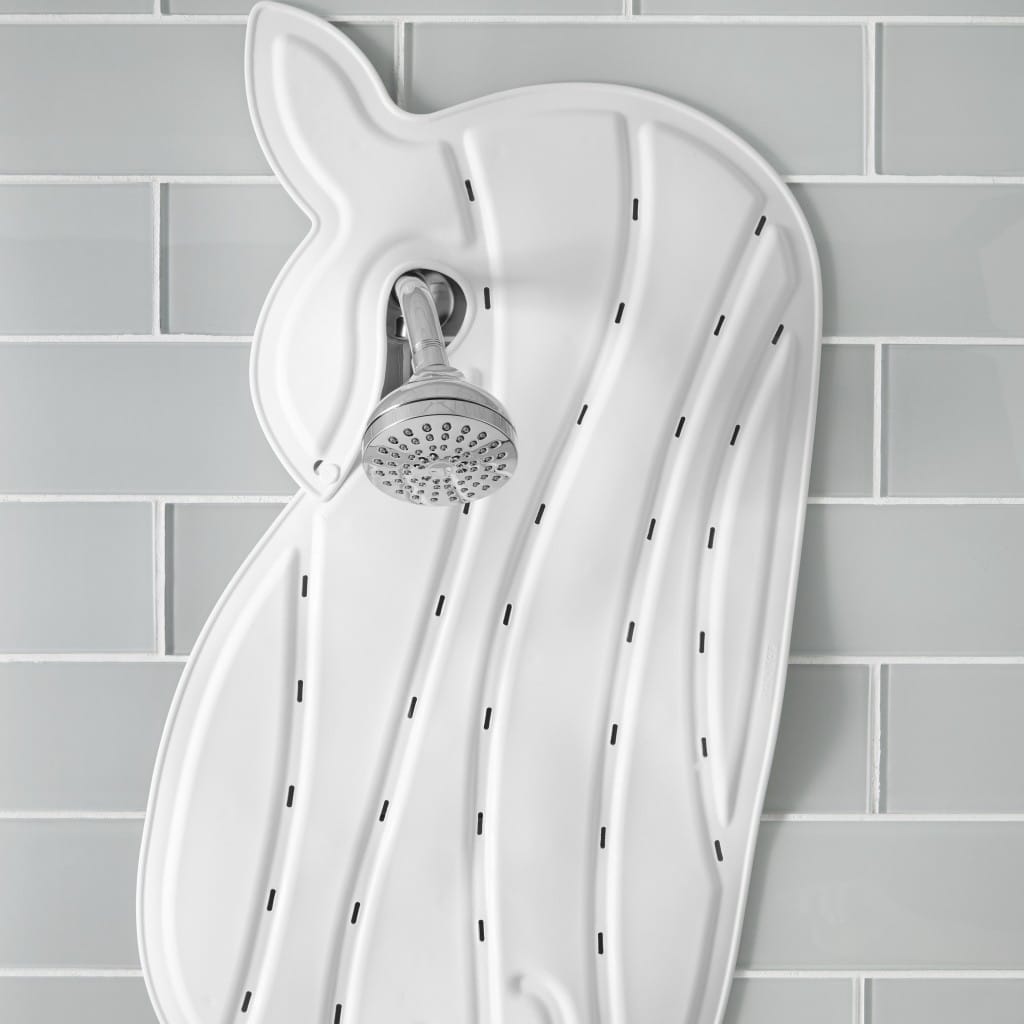 White Moby bath mat hanging by its whale tail from a shower head