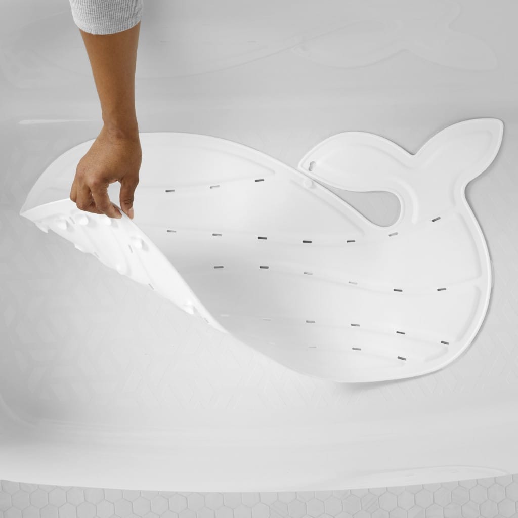 Hand lifting the white Moby bath mat from a smooth bath surface