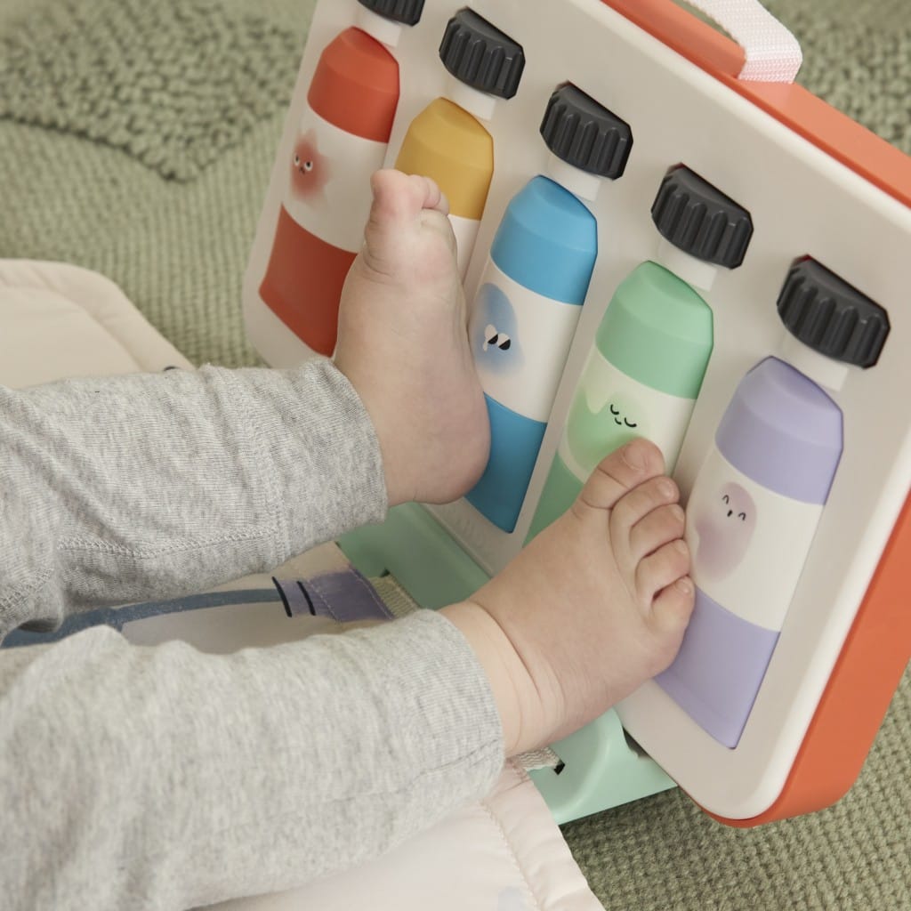 Baby pressing the Painted Dreams musical paint box keys with their feet