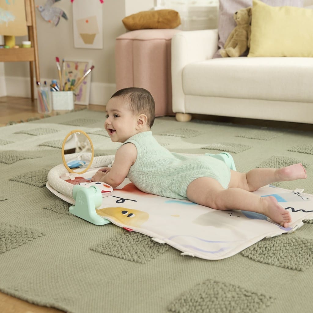 Baby enjoying tummy time with toys and mirror on the Painted Dreams playmat