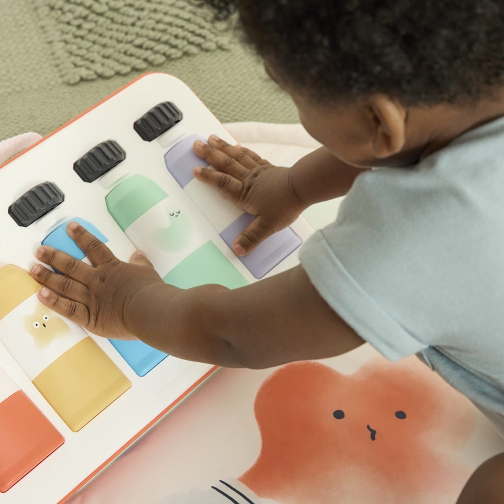 Close-up of a child pressing the Painted Dreams paint box keyboard