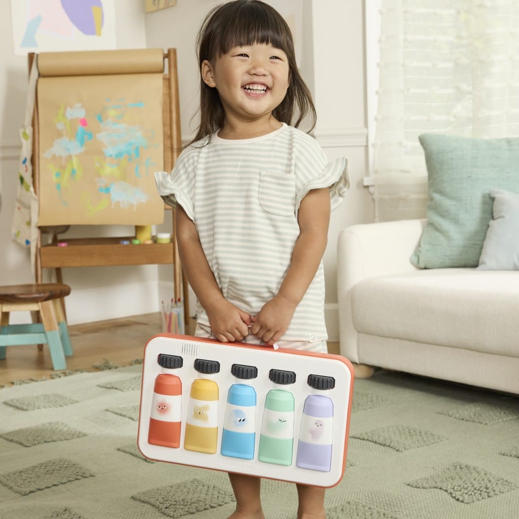 Toddler holding the detachable Painted Dreams musical paint box by its handle