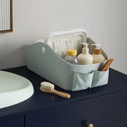 Skip Hop Sage Light Up Nappy Caddy Organised Nappies And Bottles Close view of nappies, bottles and accessories organised in the Sage caddy